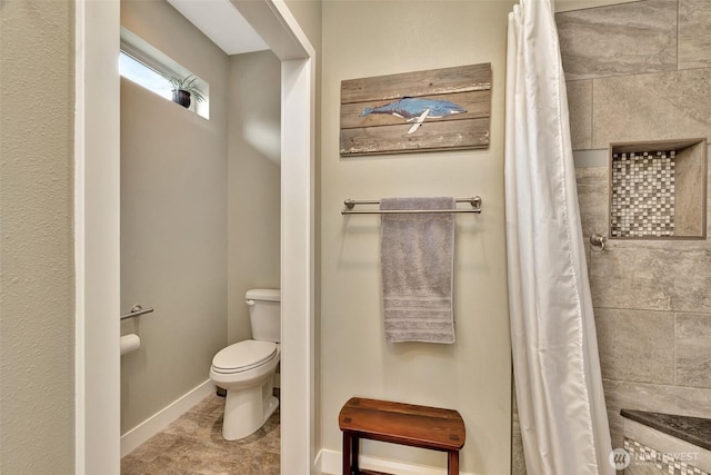 full bath featuring a shower with shower curtain, toilet, and baseboards