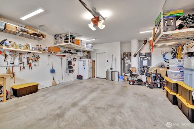 garage featuring a workshop area and freestanding refrigerator