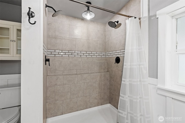 full bathroom featuring a tile shower and toilet