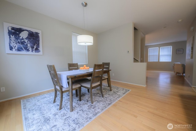 dining area with light wood-style flooring and baseboards