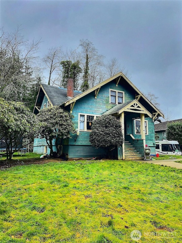 view of front of home with a front yard and a chimney