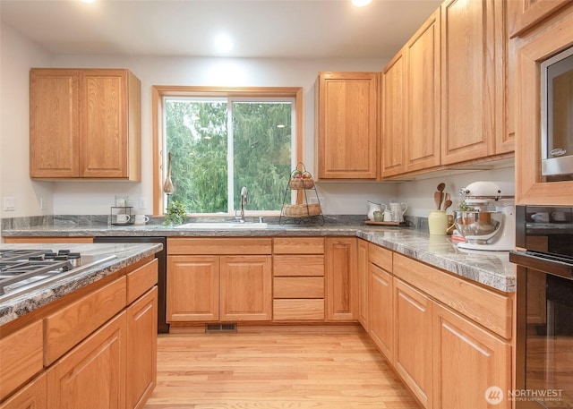 kitchen featuring tile countertops, recessed lighting, visible vents, light wood-style floors, and a sink