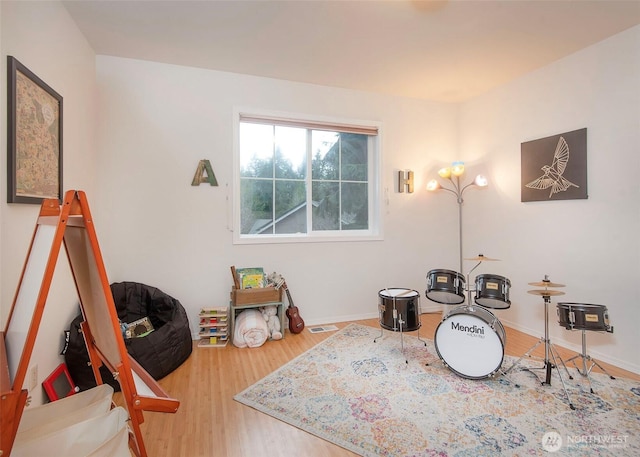 recreation room with baseboards, visible vents, and wood finished floors