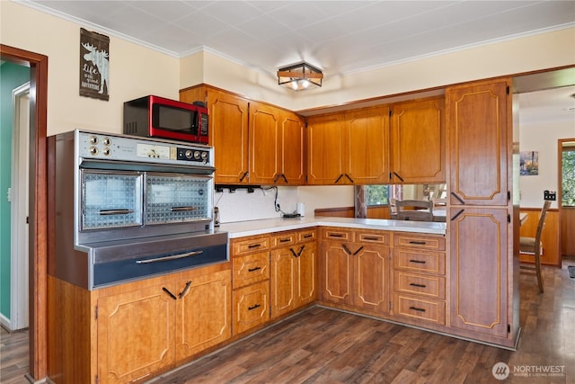 kitchen with light countertops, oven, and brown cabinets