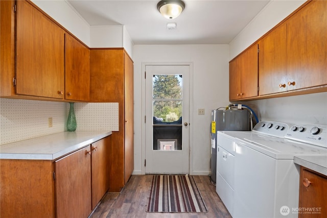 washroom with water heater, cabinet space, dark wood-type flooring, separate washer and dryer, and baseboards