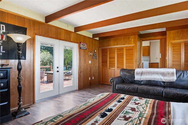 living room with wooden walls, wood finished floors, french doors, beam ceiling, and washer / dryer