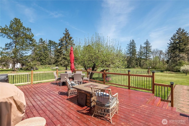 wooden terrace featuring outdoor dining area, a yard, and a fire pit