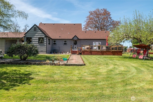 rear view of house featuring a playground, a lawn, and a wooden deck