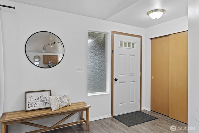 entryway featuring baseboards and wood finished floors