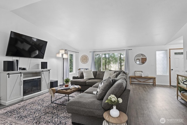 living room with a fireplace, baseboards, vaulted ceiling, and wood finished floors