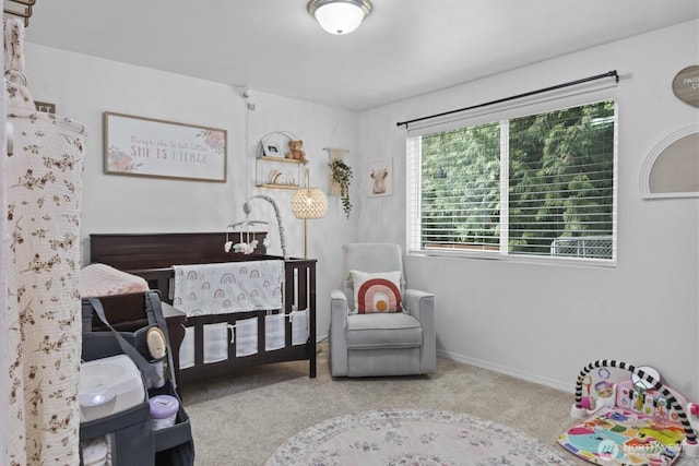 bedroom featuring a nursery area, light carpet, and baseboards