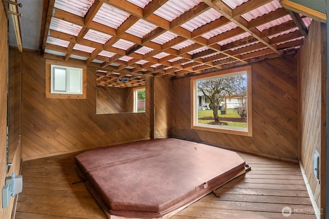 interior space featuring multiple windows, coffered ceiling, wood finished floors, and wooden walls