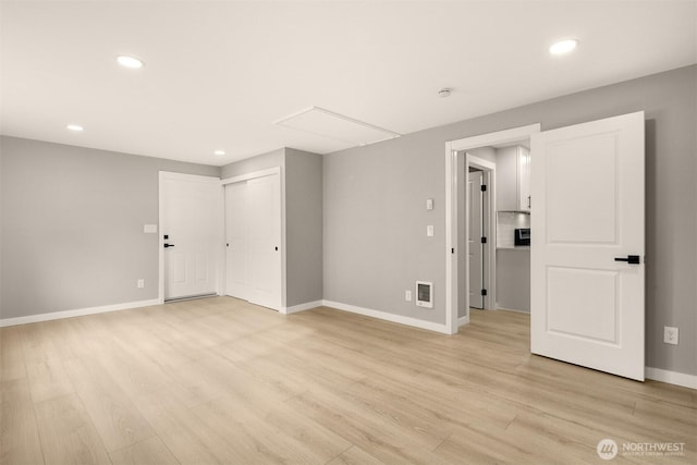 spare room featuring recessed lighting, visible vents, light wood-style floors, attic access, and baseboards