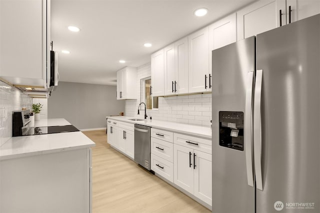 kitchen featuring stainless steel appliances, light wood-type flooring, and white cabinets