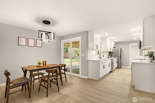 dining area featuring light wood-type flooring, baseboards, and recessed lighting