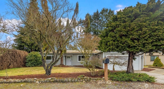 ranch-style house with a front yard, driveway, and an attached garage