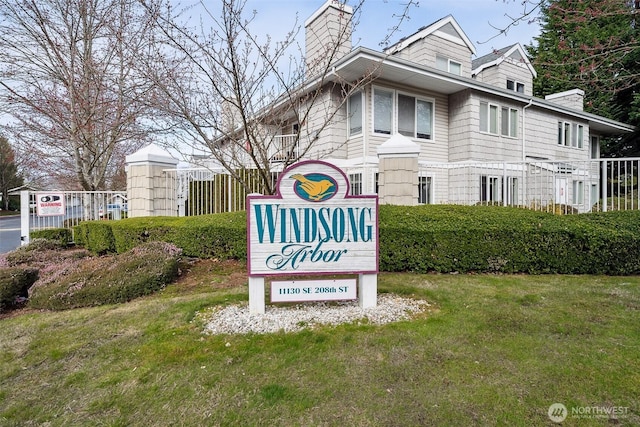 community / neighborhood sign featuring a yard