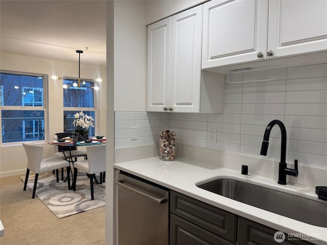 kitchen featuring light countertops, dishwasher, and white cabinetry