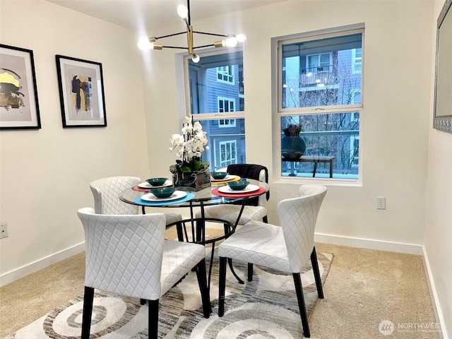 dining room featuring an inviting chandelier, baseboards, and light colored carpet