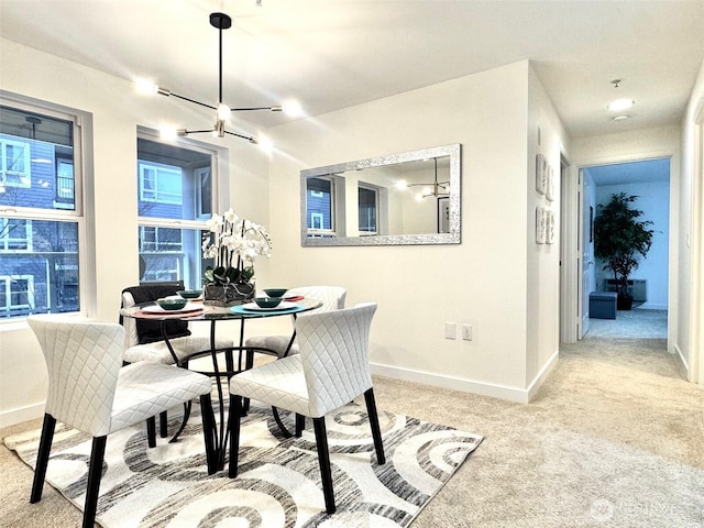 dining area featuring baseboards and light colored carpet