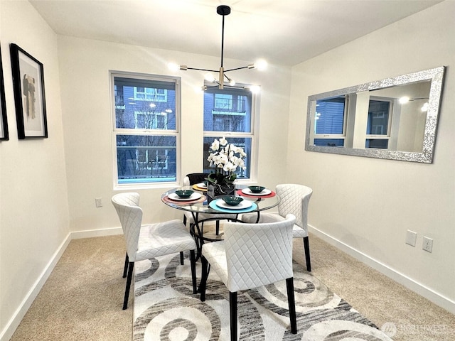 dining space featuring baseboards and light colored carpet