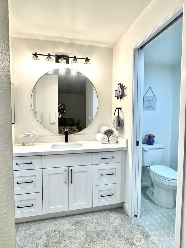 ensuite bathroom with vanity, connected bathroom, and toilet