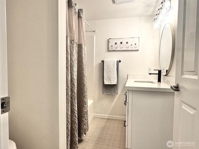 bathroom with baseboards, toilet, shower / bathtub combination with curtain, and vanity