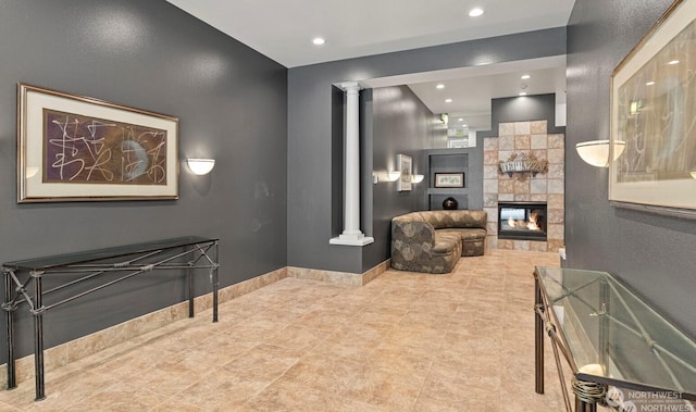 interior space with recessed lighting, baseboards, a fireplace, and ornate columns