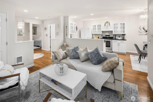 living area featuring recessed lighting, baseboards, and light wood finished floors