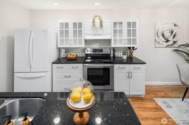 kitchen with freestanding refrigerator, white cabinets, stainless steel range with electric cooktop, wood finished floors, and under cabinet range hood