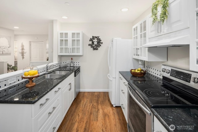 kitchen featuring under cabinet range hood, stainless steel appliances, dark wood-type flooring, a sink, and white cabinets