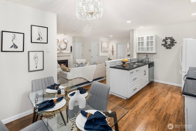 dining area with a fireplace, wood finished floors, and baseboards