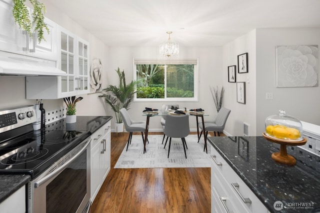 kitchen featuring white cabinetry, stainless steel electric range, dark stone counters, dark wood finished floors, and glass insert cabinets