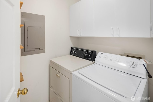 washroom with independent washer and dryer, cabinet space, and electric panel