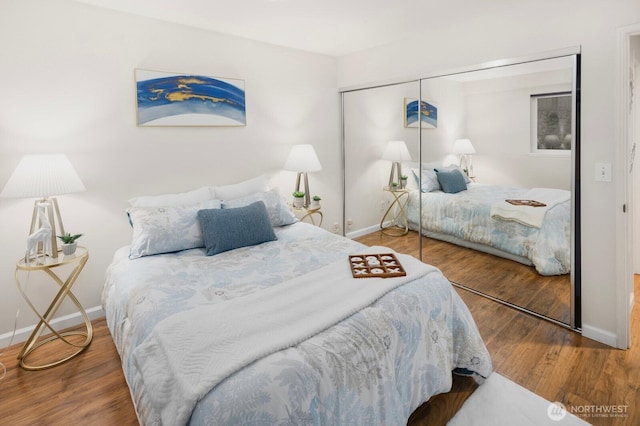 bedroom featuring baseboards, a closet, and wood finished floors