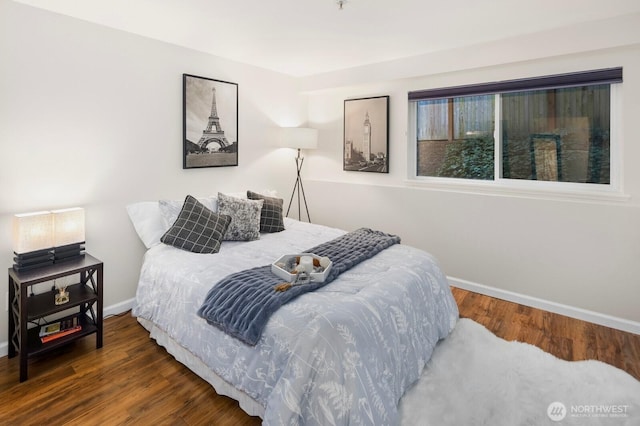 bedroom with baseboards and wood finished floors