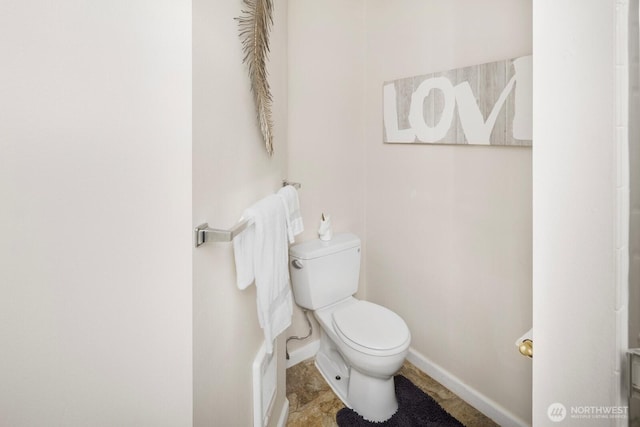 bathroom featuring baseboards and toilet