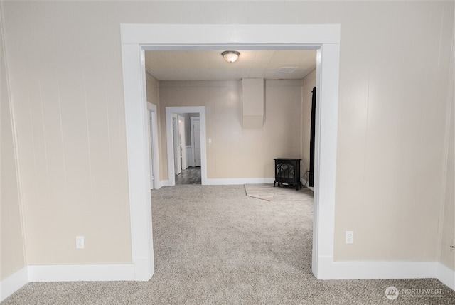 corridor featuring light carpet and baseboards