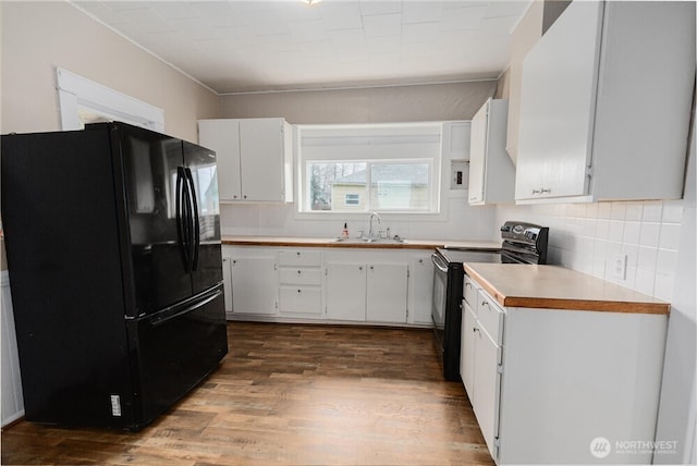 kitchen with black appliances, a sink, light countertops, and white cabinets