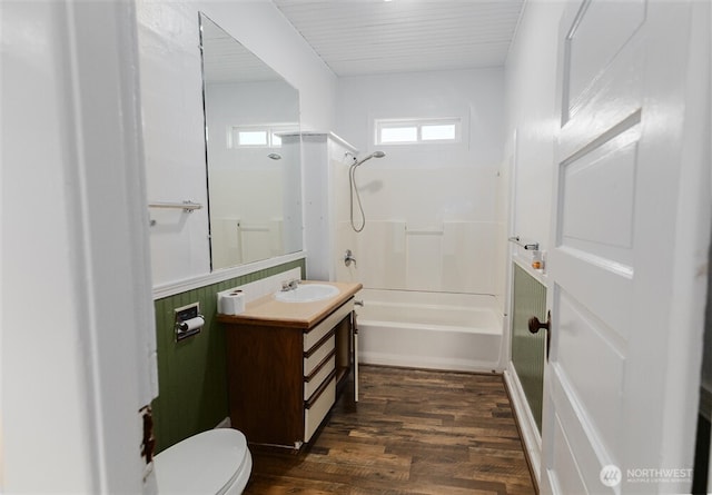 bathroom with toilet, vanity, wood finished floors, and washtub / shower combination