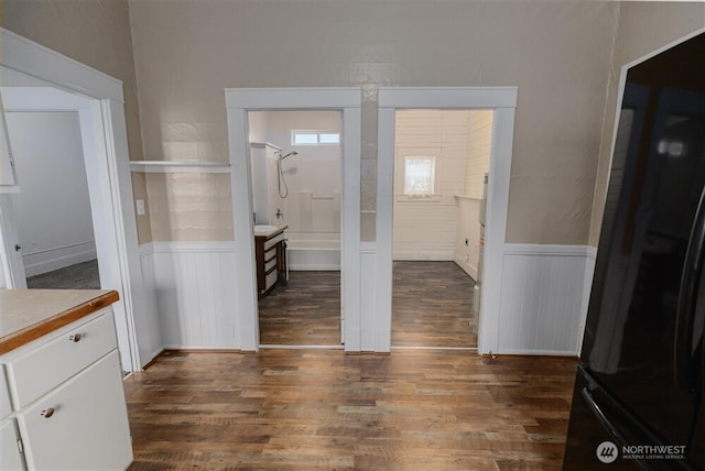 interior space featuring a wainscoted wall and dark wood-type flooring