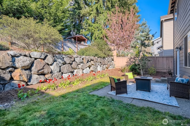 view of yard with an outdoor living space with a fire pit and a fenced backyard