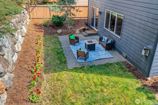 view of yard with a fenced backyard and an outdoor living space with a fire pit