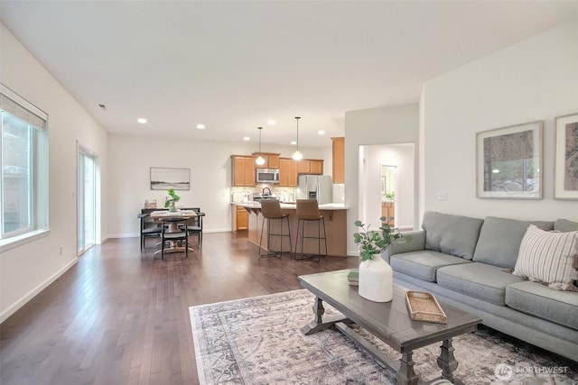 living room with baseboards, dark wood finished floors, and recessed lighting