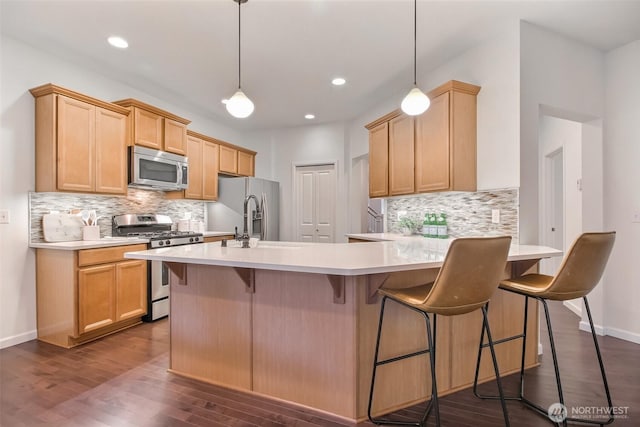 kitchen featuring appliances with stainless steel finishes, light countertops, and decorative light fixtures