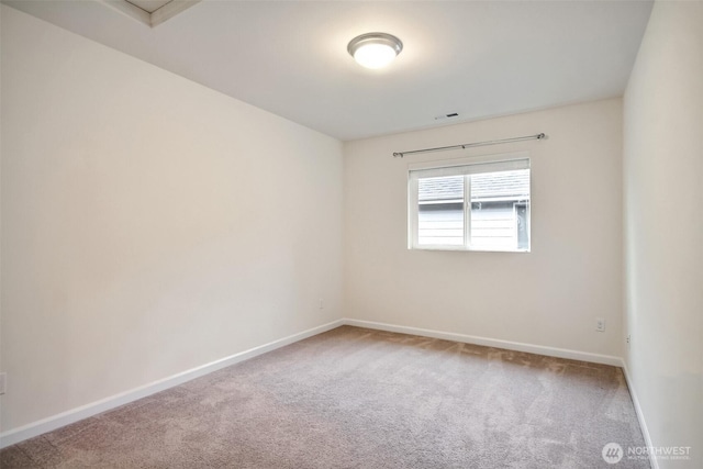 carpeted spare room with visible vents and baseboards