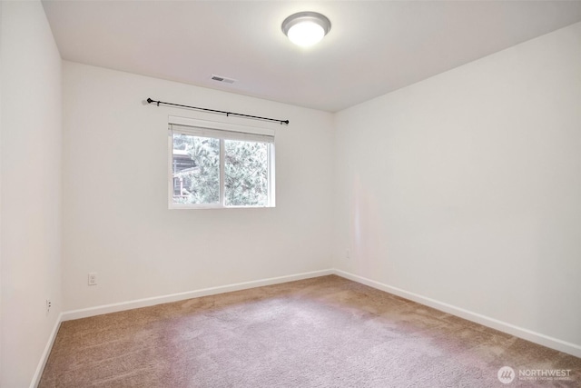 unfurnished room featuring carpet, visible vents, and baseboards