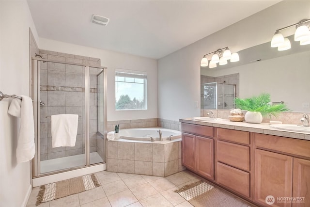 bathroom featuring a garden tub, tile patterned flooring, visible vents, and a sink