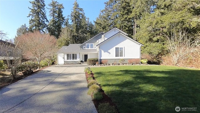 view of front of home with concrete driveway and a front lawn