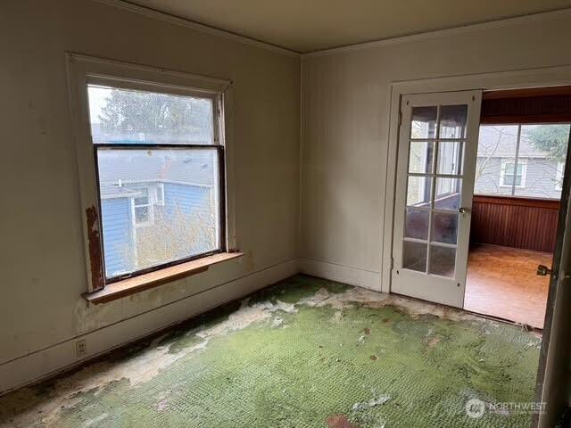 spare room with french doors and crown molding